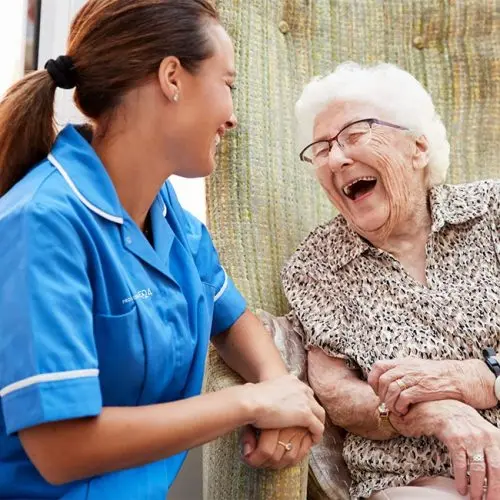A live-in carer laughing with a patient